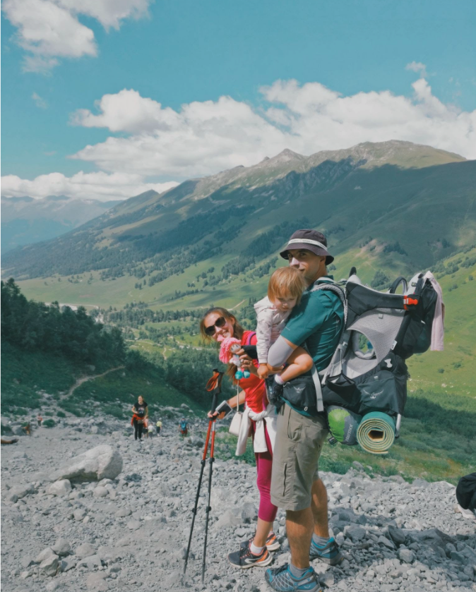 man backpacking with his family